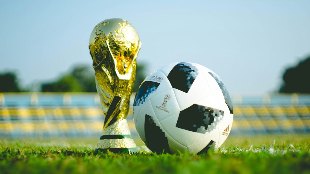 Trofeo dorado y balón sobre el césped, símbolo del Mundial 2026