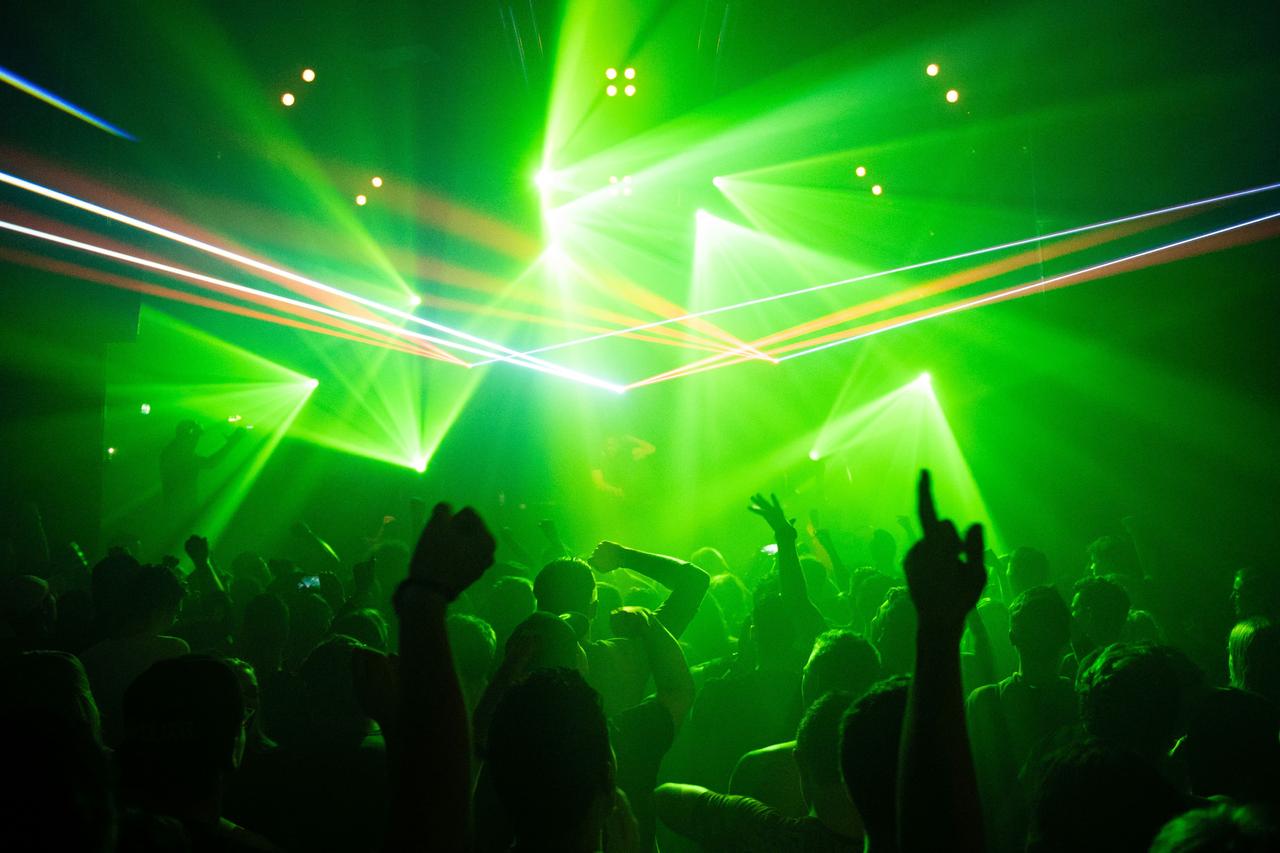 Ambiente de fiesta que evoca buscar un tercero para un trío con una app